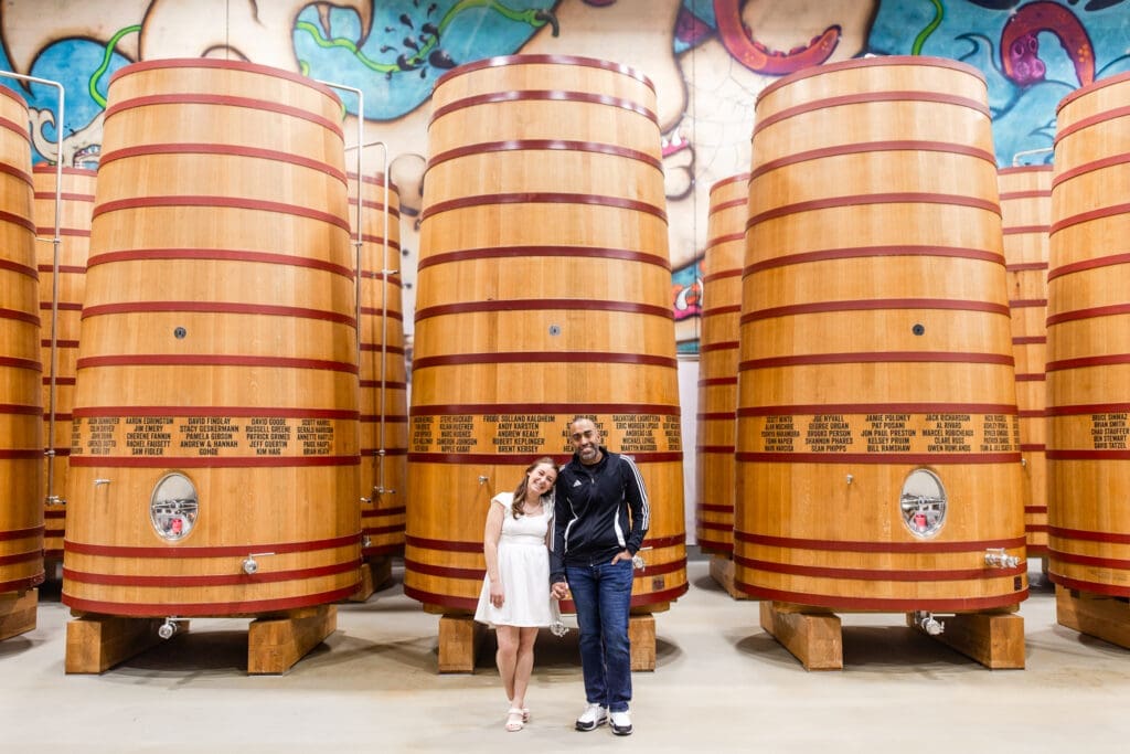 Bride and groom posing in front of massive oak barrels inside a brewery at BrewDog in Columbus, Ohio