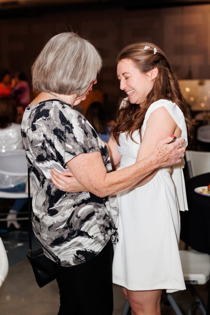 The bride gets emotional hugging one of her elderly guests