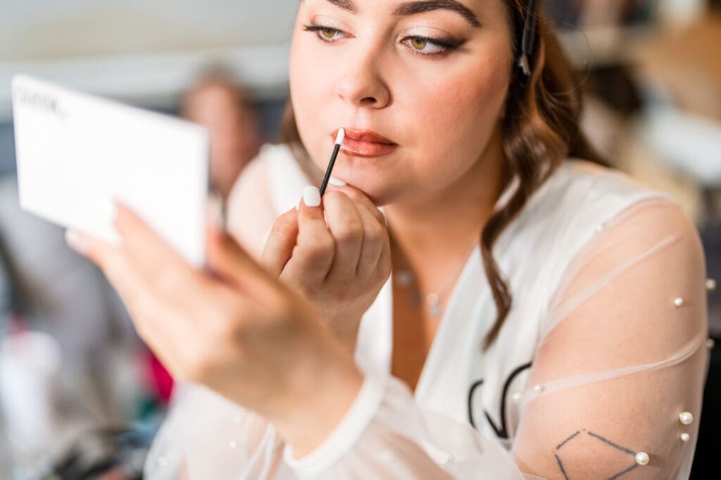 A getting ready portrait of the bride putting lip gloss on in Columbus, Ohio