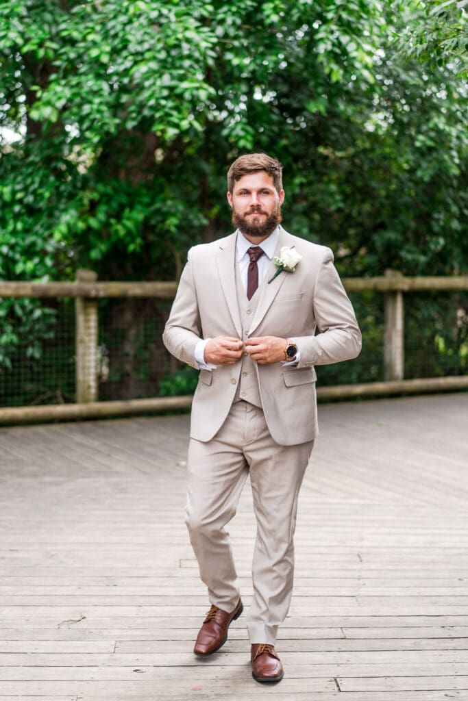 Groom portrait wearing a tan suit and brown tie at the Columbus Zoo and Aquarium