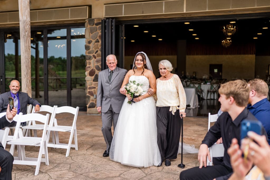 The bride and her grandparents walking down the aisle at the Columbus Zoo and Aquarium Africa Event Center
