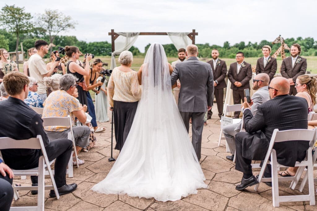 The bride and her grandparents walking down the aisle at the Columbus Zoo and Aquarium Africa Event Center