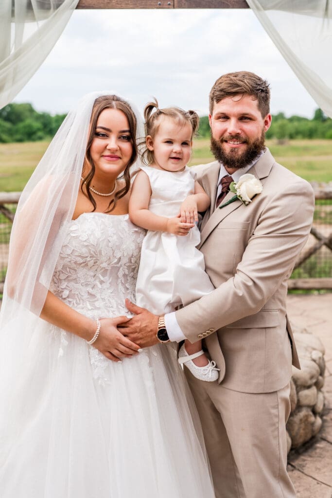 Family portrait of the bride, groom, and their daughter at the Columbus Zoo and Aquarium