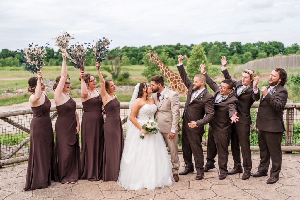 Wedding party photo with a giraffe in the background at the Columbus Zoo and Aquarium