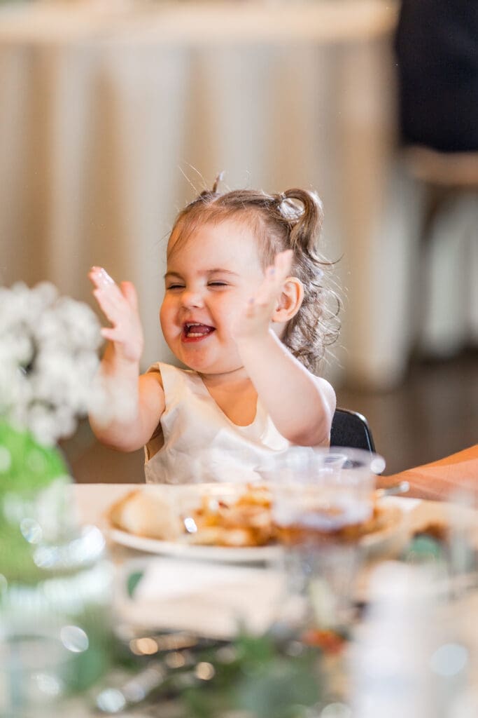 The bride and groom's daughter claps during toasts at the Columbus Zoo and Aquarium