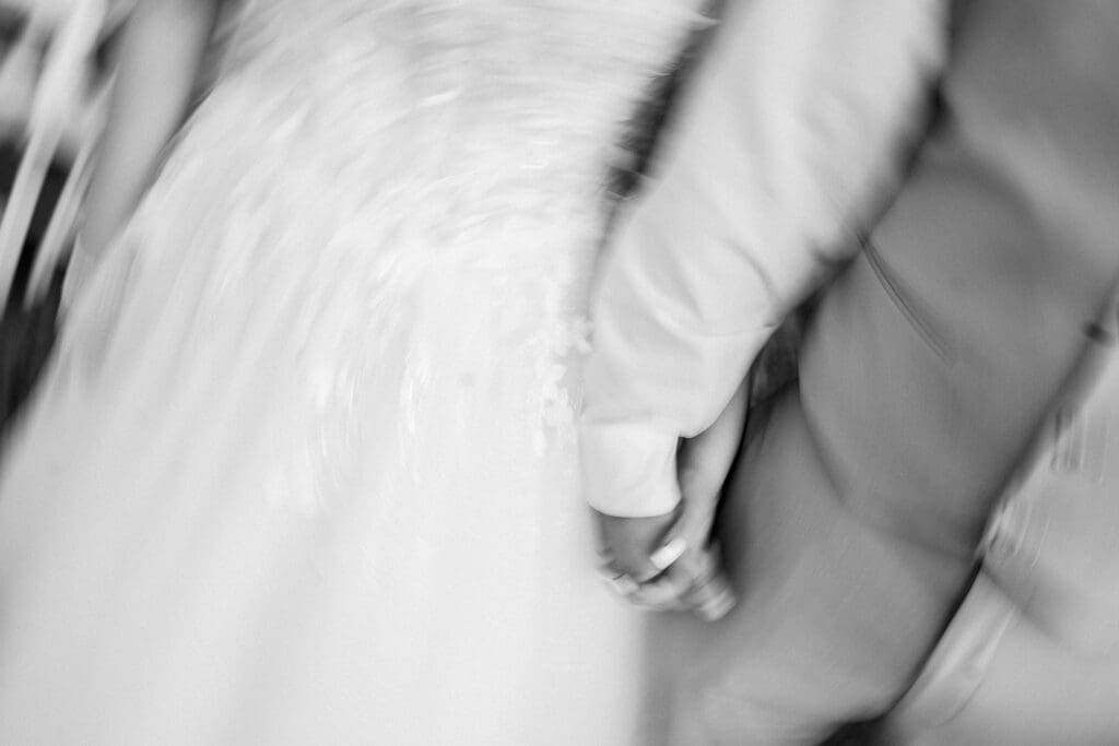 Blurry detail photo of the couple holding hands