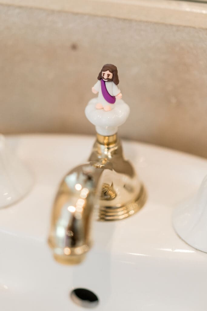 Mini Jesus figurine on a faucet