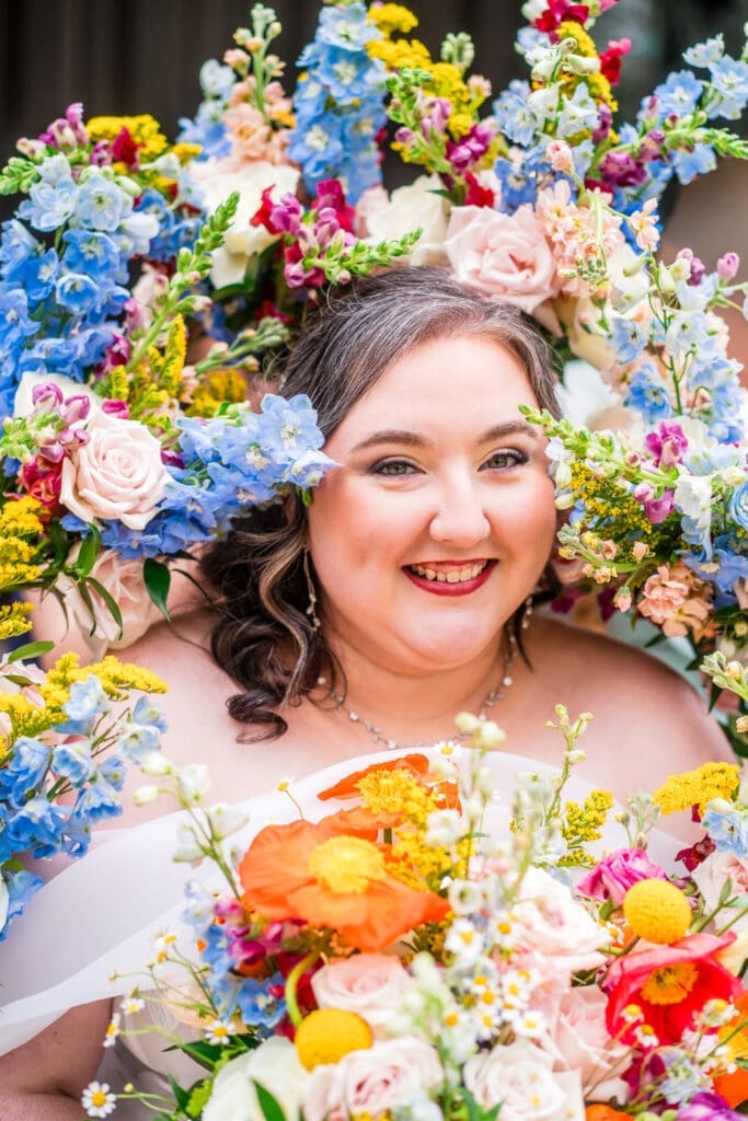 Bridal portrait with colorful wildflower bouquets surrounding her face at the Dempsey Event Center in Delaware, Ohio.