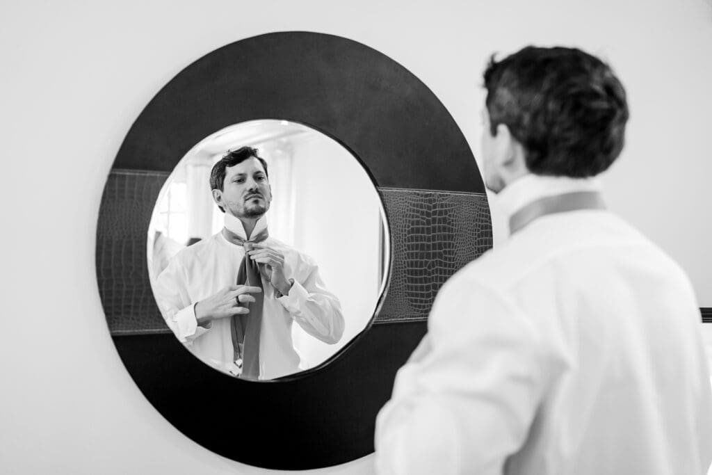 Getting ready photo of the groom looking in the mirror at the Dempsey Event Center in Delaware, Ohio.
