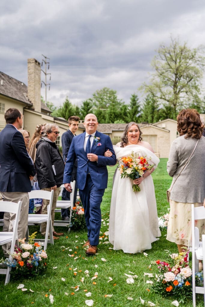 The bride and her father walk down the ceremony aisle at the Dempsey Event Center in Delaware, Ohio.