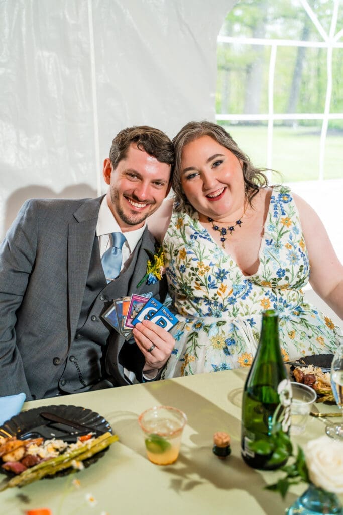 The Groom holds up game cards with his bride at the Dempsey Event Center in Delaware, Ohio.