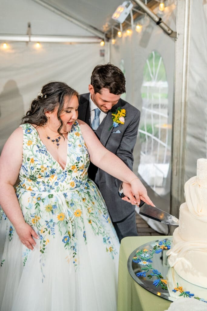 Wedding couple cuts the cake at their tented reception at the Dempsey Event Center in Delaware, Ohio.