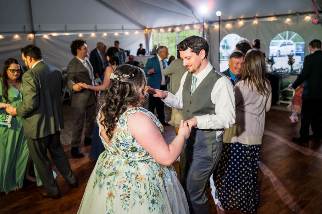 Wedding couple dances at a tented wedding reception at the Dempsey Event Center in Delaware, Ohio.