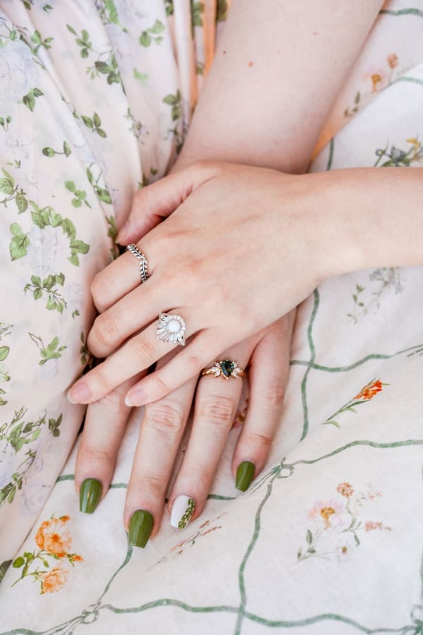 Handmade engagement rings for two women and patterned dressed for their engagement photos