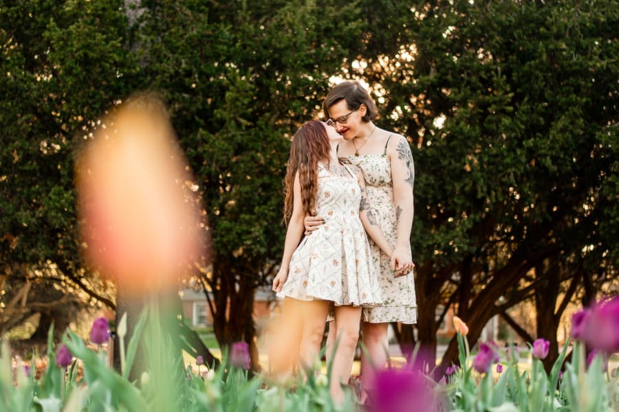 A LGBTQ+ couple embracing in the tulips at Inniswoods Metro Gardens