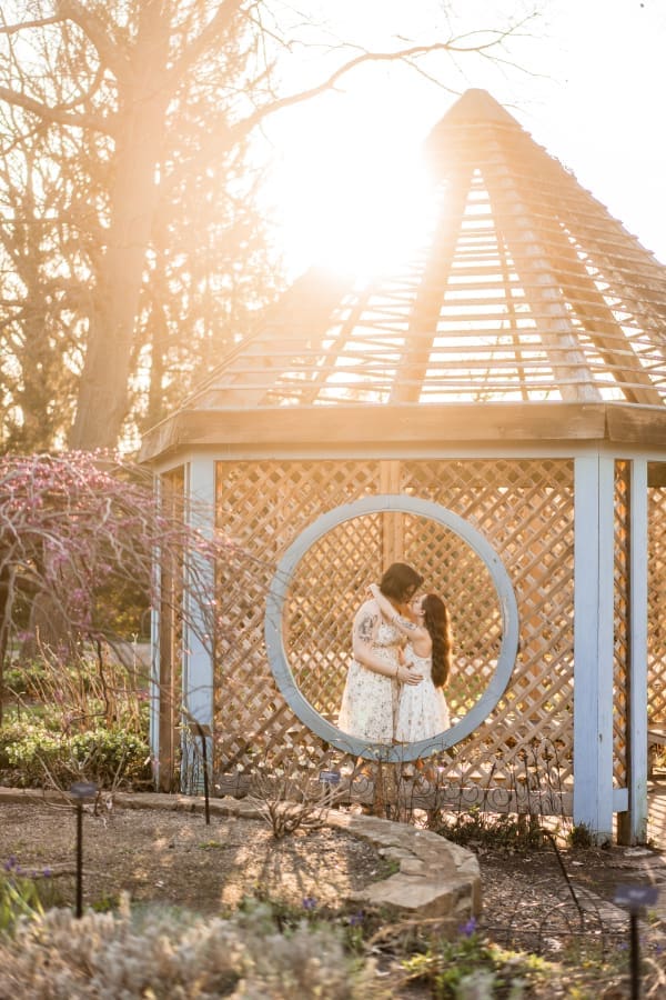 An artistic golden hour engagement photo of a LGBTQ+ couple at Inniswoods Metro Gardens