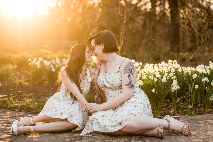 A golden hour spring engagement photo of a LGBTQ+ couple at Inniswoods Metro Gardens