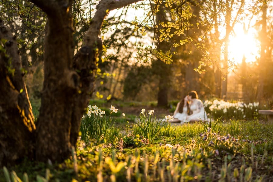 A golden hour spring engagement photo of a LGBTQ+ couple at Inniswoods Metro Gardens