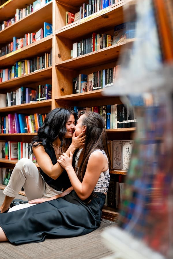 Couple sitting amongst the stacks for their engagement session at the Book Loft in Columbus, Ohio.