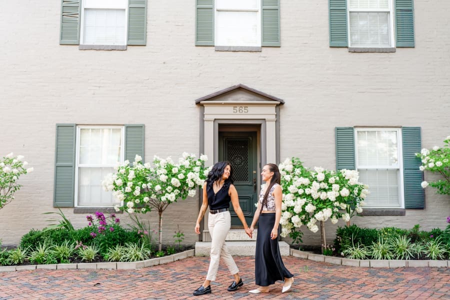 Engaged couple walking in front of a home in German Village