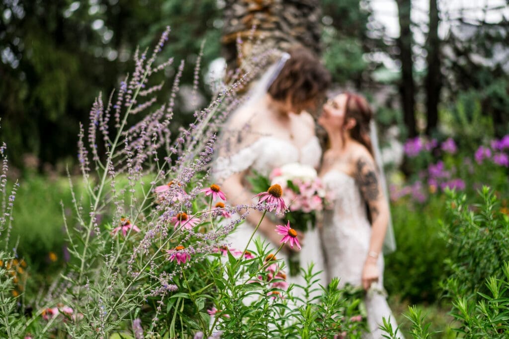 Couple portrait of two brides in the gardens at Wagnalls Memorial Library