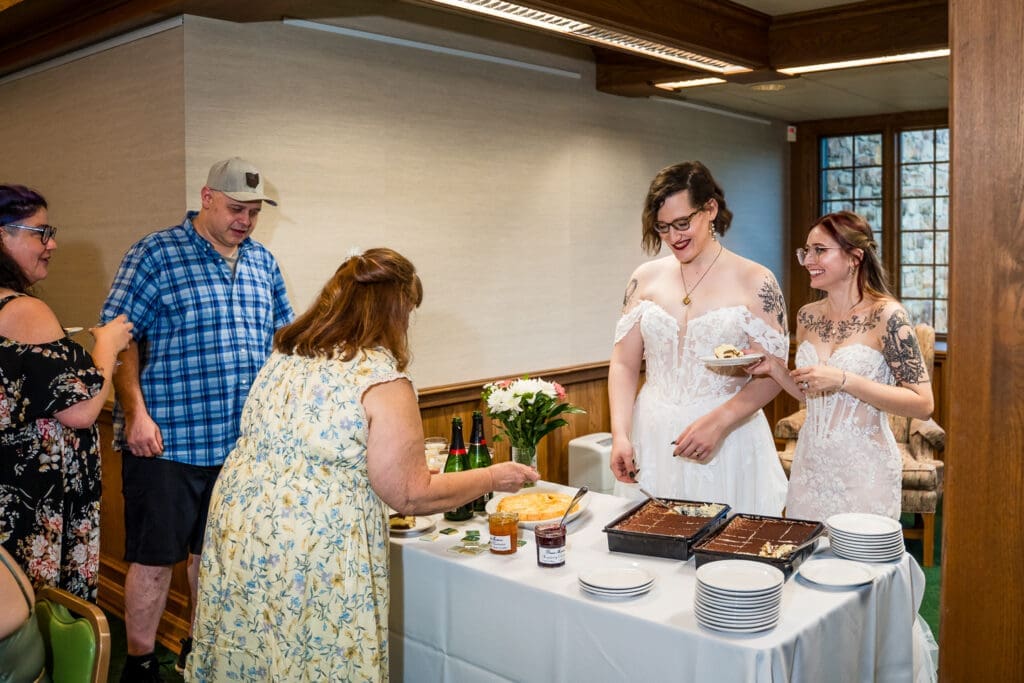 Brides serving their guests at their Columbus Ohio LGBTQ+ wedding at Wagnalls Memorial Library