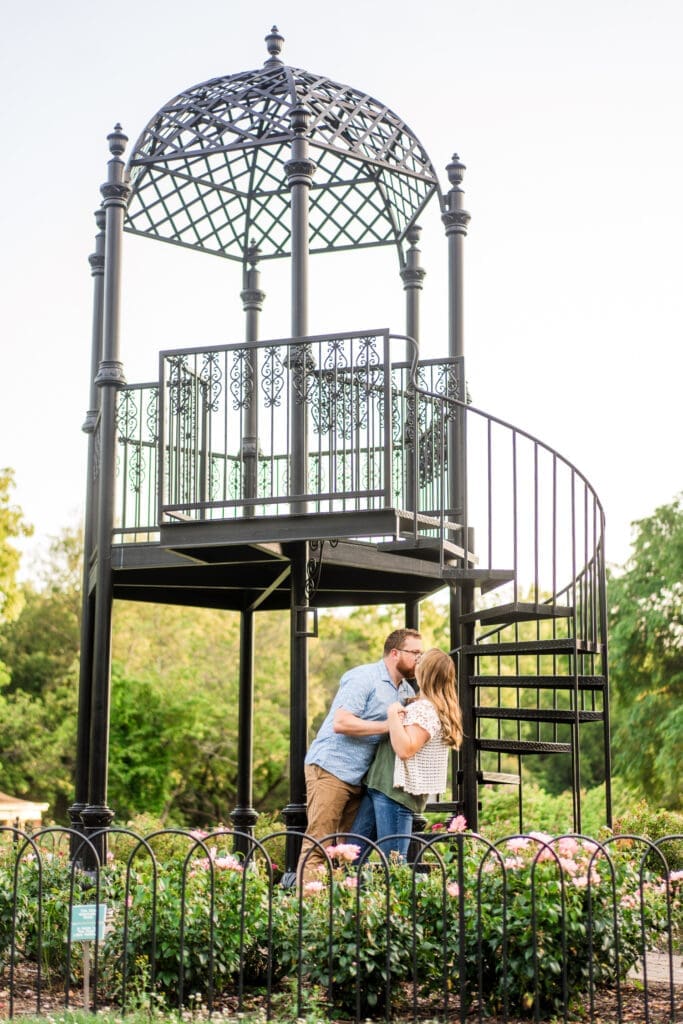 Engagement photo at the iron tower at Columbus Park of Roses.