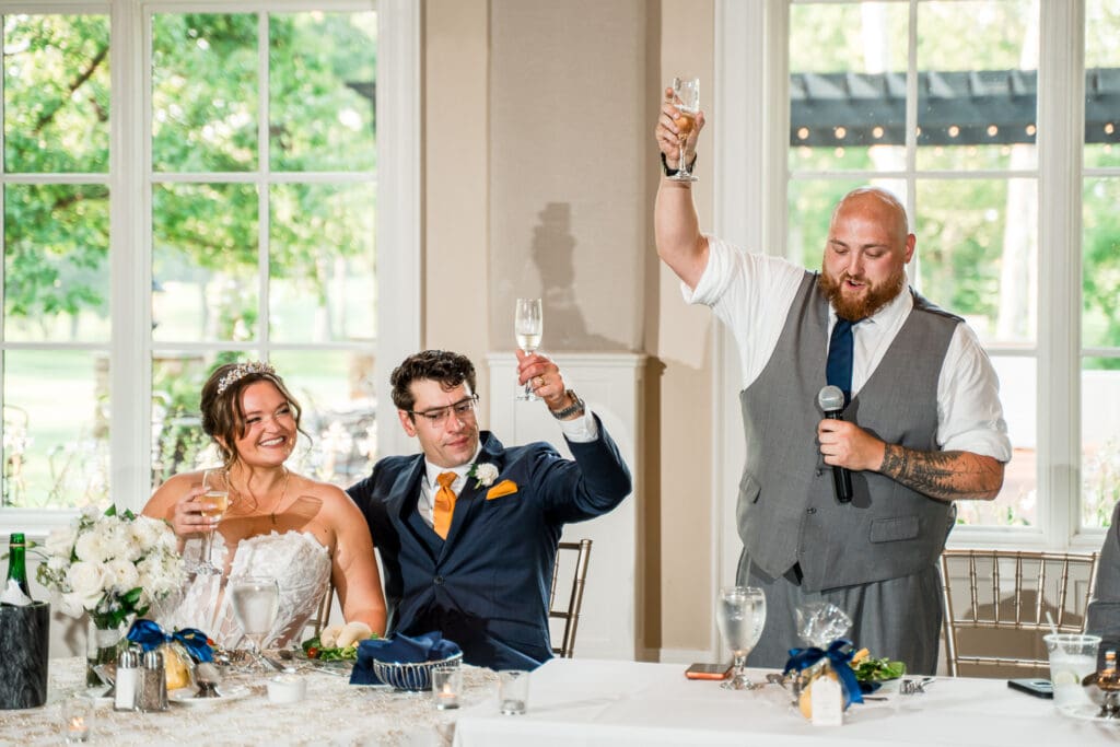 Toasts at a navy and gold themed wedding at Pinnacle Golf Club in Grove City, Ohio.