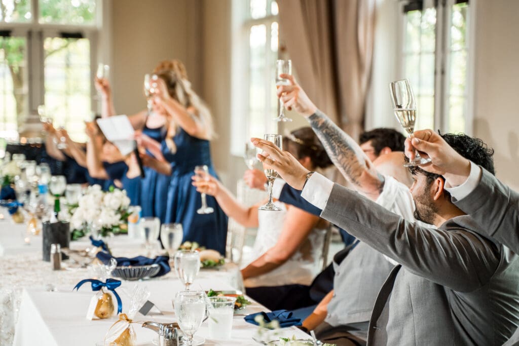 Toasts at a navy and gold themed wedding at Pinnacle Golf Club in Grove City, Ohio.
