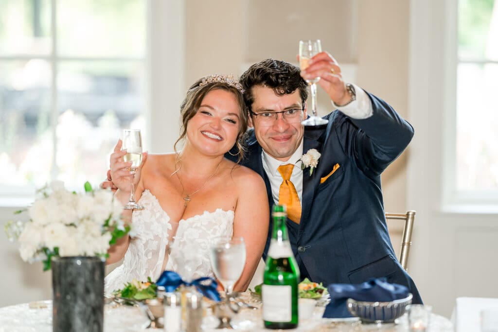 Toasts at a navy and gold themed wedding at Pinnacle Golf Club in Grove City, Ohio.